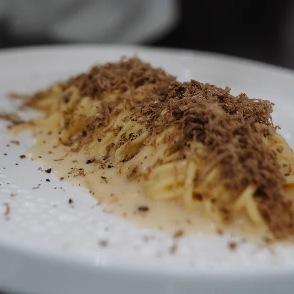 Koch raspelt Trüffel auf Pastagericht