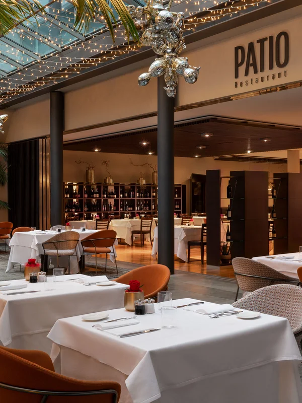 Elegantes Restaurant mit gedeckten Tischen und dekorativer Deckenbeleuchtung